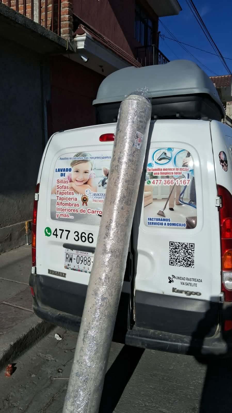 Vehículo de servicio con publicidad de limpieza de tapicería y alfombras.